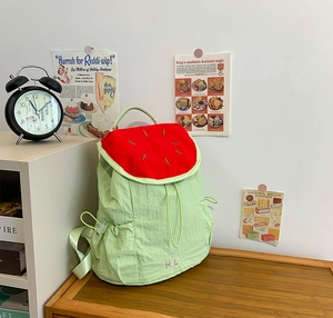 Close-up of watermelon-shaped backpack with red fruit texture and hello embroidery