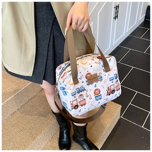 Close-up of white cartoon tote bag with cute lion prints and brown adjustable straps