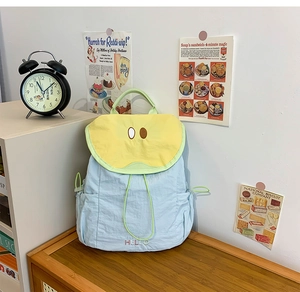 Detailed view of light blue and yellow nylon kids backpack with cute eyes embroidery