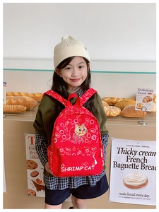 Detail view of red kids backpack featuring cute Shrimp Cat cartoon and zipper design