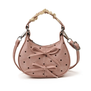 Pink polka dot mini kids handbag with cute bows and lace detail on white background
