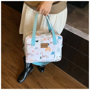 Detail of cute cartoon animal print diaper bag with blue handles and spacious interior