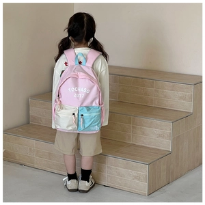 Detail view of pink and beige kids backpack with letter print on stylish canvas material