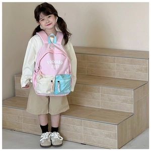 Detail view of colorful kids backpack with front zipper pockets and logo emblem