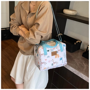 Detail of cartoon animal print tote bag with blue handles and adjustable shoulder strap