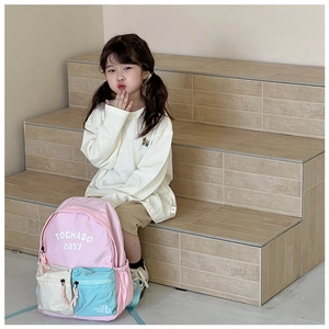 Pink school backpack with multi-pocket design and letter embroidery shown on a model