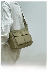 Detail of army green canvas tote with dual front pockets and adjustable strap