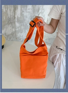 Detail of washed canvas shoulder bag featuring front layered pocket and adjustable strap