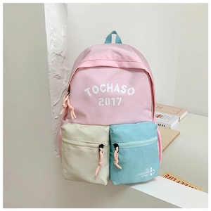 Detail of color-block canvas school backpack with multiple zip pockets and letter print