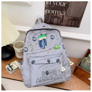 Detail view of cartoon frog prints and functional side pockets on grey school backpack