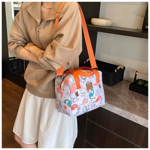 Detailed view of cartoon dinosaur print storage bag with orange adjustable straps