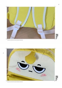 Detail of yellow school bag with funny cartoon face embroidery and adjustable pink buckles