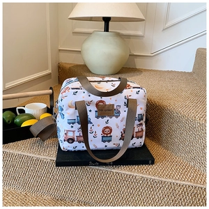Detail of cartoon lion and train print on canvas baby diaper bag with brown straps