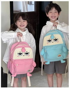 Detail of pink and blue kids backpacks with cartoon faces and 3D limb features
