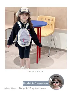 Kids purple and white backpack styled with trendy drawstring hat and outdoor outfit