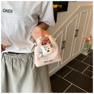 Détail du mini sac à main en cuir rose avec lettres HELAHE et adorable charm chien en peluche