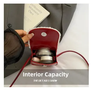 Gros plan sur la capacité interne du mini sac bandoulière rouge avec dentelle fine