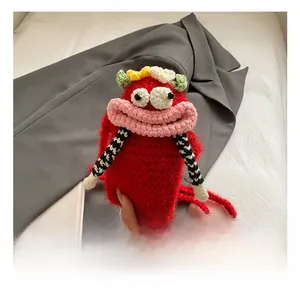 Detail of red handmade crochet monster mini bag with large eyes and pink lips strap