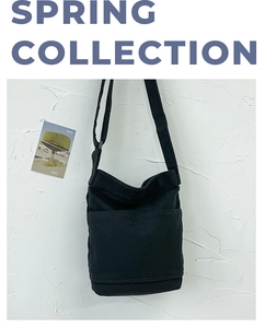 Close-up of black washed canvas shoulder bag featuring a minimalist front pocket design