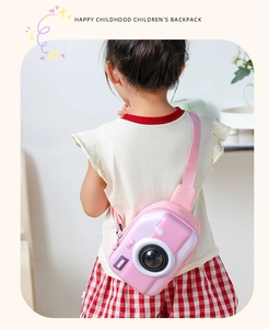 Pink camera-shaped EVA crossbody bag shown on a child model with an adjustable strap