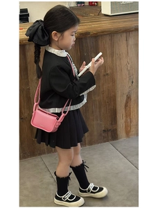 Close-up of children's mini crossbody bag in pink with preppy style outfit detail