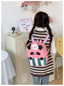 Girl wearing cartoon panda backpack with ice cream design and rainbow straps at home