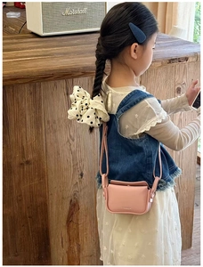 Pink leather crossbody bag for kids with a white polka dot lace bow headband accessory