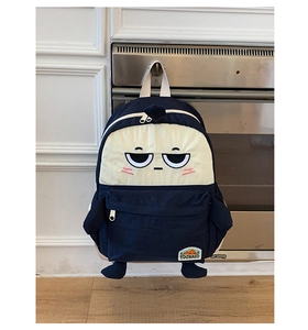 Detailed view of cartoon backpack with funny facial embroidery and front zipper pocket