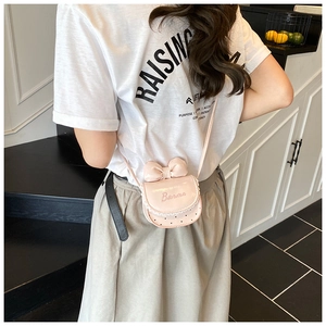 Détail du mini sac bandoulière rose avec nœud, bordure en dentelle et cœurs pour filles