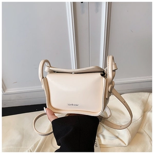 Detail of a beige cream mini crossbody bag for kids with flap closure and shoulder strap