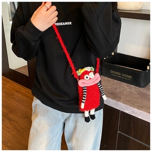 Detail of red handmade crochet crossbody bag with funny cartoon character design
