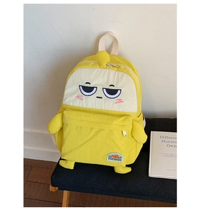 Detail of cartoon embroidery and brand label on yellow high-capacity student backpack