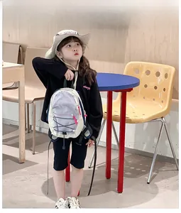 Kids contrast color drawstring backpack shown in use with adjustable straps and pink zipper