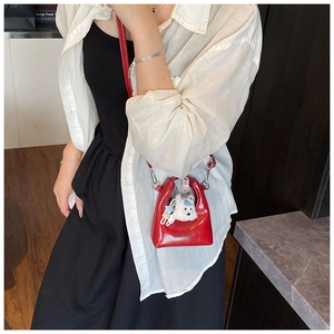 Mini sac à main trapèze rouge avec breloque chiot en peluche et logo HELARK noir