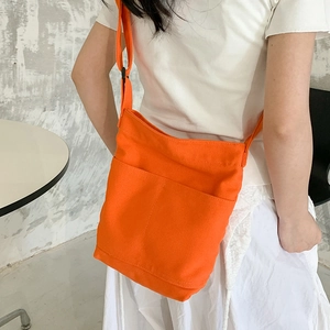 Minimalist bright orange washed canvas crossbody bag with adjustable wide strap and front pockets