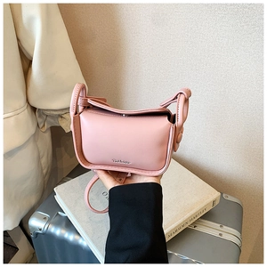 Detailed view of a pink mini PU leather crossbody bag featuring a silver metal logo