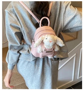 Détail d'un mini sac à dos rose en PU avec lapin en peluche sur un sweat gris