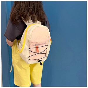 Detail view of pink and beige kids drawstring backpack with side yellow piping and buckles