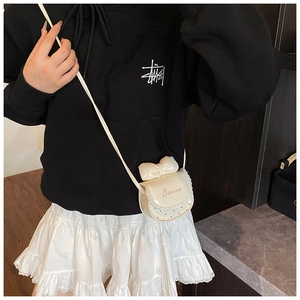 Détail du mini sac bandoulière blanc demi-lune avec un grand nœud et texte Banma