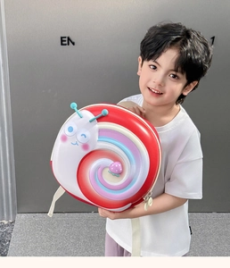 Toddler held a cute snail-shaped hardshell backpack in red and macaron colors