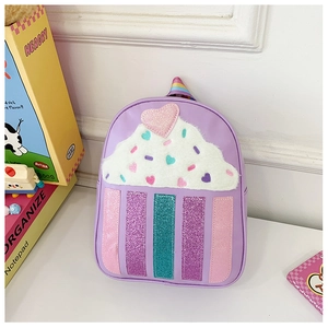 Detail of a purple cupcake-shaped kids backpack with plush cream and glitter heart decor