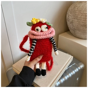 Detail of red handmade crochet monster bag with cartoon eyes and pink sausage lips