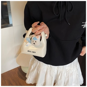 Vue détaillée mini sac à main blanc nacré avec pendentif chien en peluche et logo Helahe