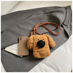 Détail d'un sac bandoulière chiot en peluche marron sur une veste grise avec accessoires