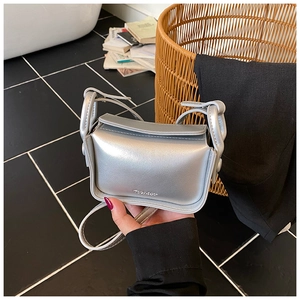 Detail of silver metallic mini crossbody bag for kids with glossy finish and logo