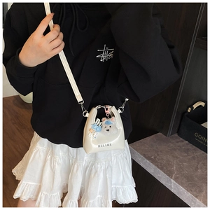 Détail du mini sac à bandoulière blanc crème avec pendentif mignon et logo HELAHE