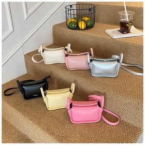 Mini synthetic leather crossbody bags displayed in multiple colors on home steps