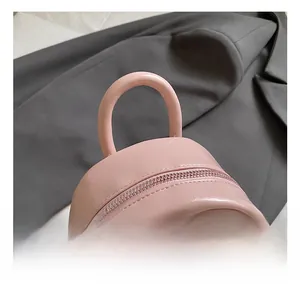 Détail du sac à dos en similicuir rose avec bordure en peluche et zip en métal argenté