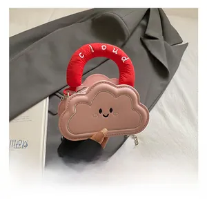 Close-up of pink cloud bag with smile embroidery and red knit handle with cloud text
