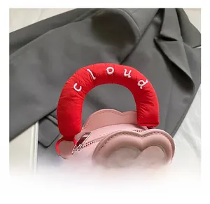 Detailed view of pink cloud-shaped kids bag with red handles and cloud embroidery